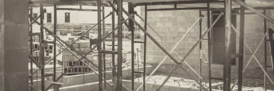 Image is a grayscale photo of a building under construction.
